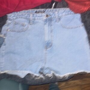 Woman’s new tags still on light denim shorts from pretty little thing